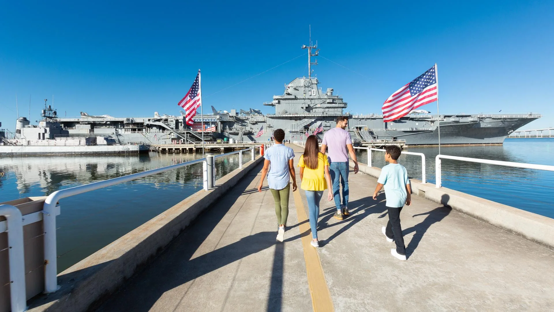 A family walks the pier toward the USS Yorktown at Patriots Point, Mount Pleasant, SC