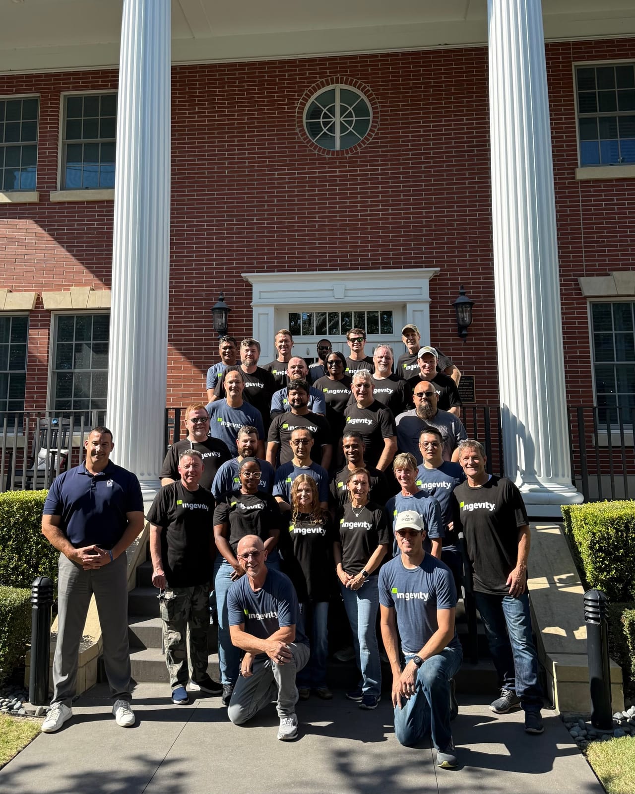 Twenty-seven Ingevity volunteers posing on the front steps of the Charleston Fisher House in matching branded t-shirts